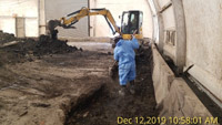 December 2019 - Scraping Surface of Soil Solidification to Remove Debris and Loose Material Before Capping in Bulkhead Tent